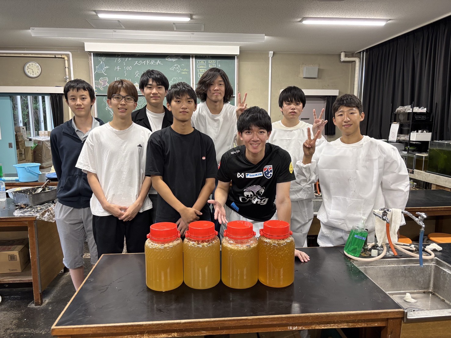 採れた蜂蜜の瓶を囲んだ集合写真